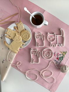 cookie cutters are sitting on a table next to a cup of coffee and yarn