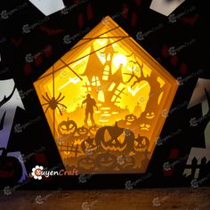 a paper lantern that looks like it is in the shape of a house with pumpkins and