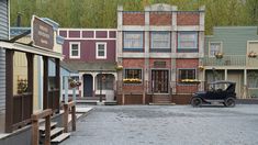 an old car is parked in front of some buildings