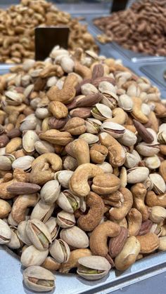 assorted nuts are displayed in trays on display