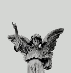 an angel statue is shown with its hands in the air