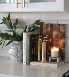 a candle and some books on a kitchen counter