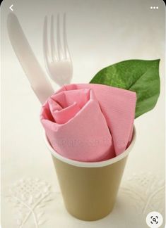 a pink napkin and fork in a cup