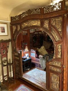 an ornate wooden room divider with carved wood carvings on the doors and sides, in front of a mirror