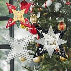 a christmas tree with ornaments hanging from it's branches in front of a window