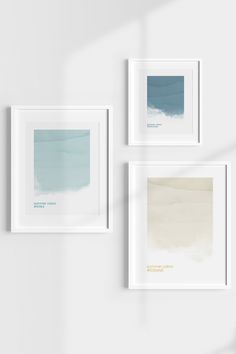 three framed art pieces hang on the wall next to each other, one with blue and white watercolors