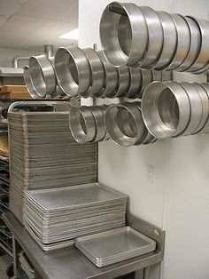 stacks of pans are stacked on top of each other in a commercial kitchen area