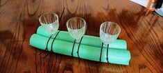 three wine glasses sitting on top of green napkins