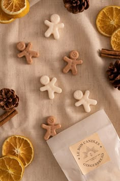 orange slices, cinnamon sticks, and ginger cookies are arranged on a table with pine cones