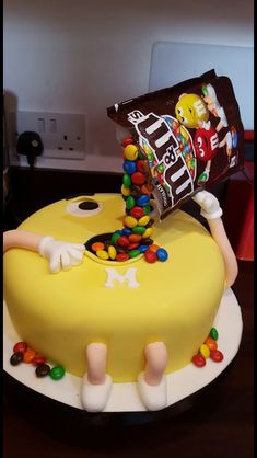 a birthday cake decorated with candy, candies and a bag of m & m's