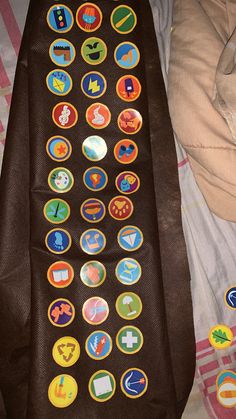 there is a tie with many different buttons attached to it on top of a bed