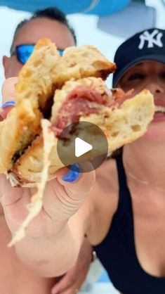 a woman holding up a half eaten sandwich