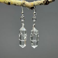 Clear Quartz Crystal Dangle Earrings, Quartz Gemstone Wire Wrapped Earrings  You will receive 1 (ONE) Pair of Clear Quartz Dangle Earrings like the item pictured.   Item description Stone: Clear Quartz  Finish: Polished, wire wrapped Drop length: 50mm Length: 30mm Width: 10mm These raw crystal earrings celebrate the natural beauty of clear quartz jewelry. The translucent beauty of quartz crystal captures the light and adds a touch of elegance to any outfit. Handmade with care, these gemstone ear Earrings Crystal Stones, Clear Quartz Earrings, Astrology Outfits, Clear Quartz Jewelry, Raw Crystal Earrings, Crystal Quartz Earrings, Quartz Crystal Jewelry, Silver Crystal Earrings, Emerald Green Earrings