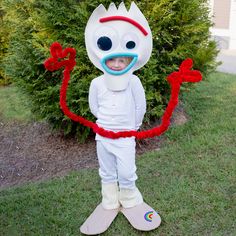 a young boy dressed as a cartoon character holding a red string in front of his face