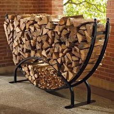 a bench made out of logs in front of a brick wall and tree trunk structure