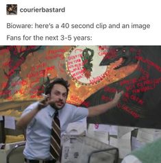 a man in a shirt and tie standing next to a wall with writing on it