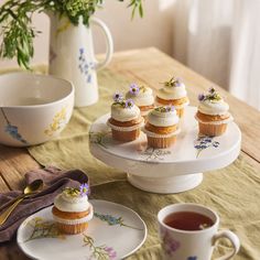 cupcakes and tea on a table with flowers