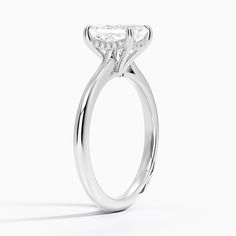 a white gold ring with a princess cut diamond in the center, on a white background