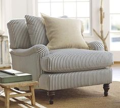 a blue and white striped chair sitting in front of a window