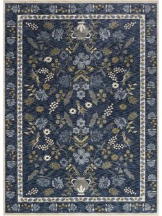 a blue rug with flowers and leaves on the bottom, in front of a white background