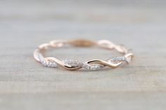 a white gold wedding band with diamonds in the shape of an intertwined ring on top of