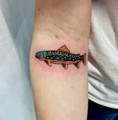 a colorful fish tattoo on the arm