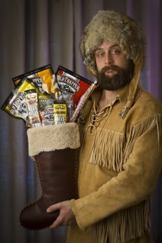 a man in a fur hat holding a boot filled with candy and candies,