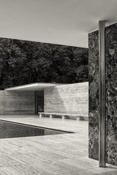 a black and white photo of a building with a pool in the middle of it