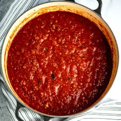 a pot filled with sauce sitting on top of a table