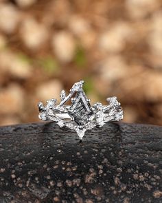 a diamond ring sitting on top of a rock