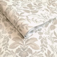 a wallpaper with leaves and vines on it's white background, as well as a roll of tape