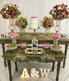 a wooden table topped with cakes and flowers next to a sign that says aw & w