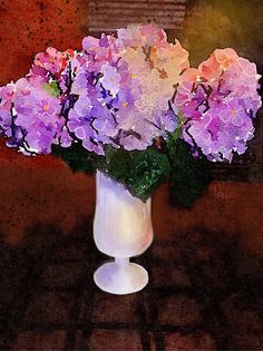 a white vase filled with purple flowers on top of a table