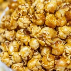 close up view of caramel popcorn kernels in a white bowl on a table