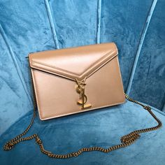 SHOP MORE LUXURY PRODUCTS HERE Description Saint Laurent Cassandra Medium Chain Bag Dark Beige For Women 8.7in/22cm YSL Size: 22 x 16 x 6 cm / 8.7 x 6.3 x 2.4 inches (Length x Width x Height) Saint laurent monogram bag with flap closure and studs on the sides, two compartments, a flat front pocket with a ysl monogram fastening, and double curb chain.Folded shoulder strap drop : 34cm; strap drop : 60cmBronze metal hardwareY-shaped clip fasteningOne slit pocketOne zippered pocket Includes box, dus Bag Dark, Yves Saint Laurent Bags, Monogram Bag, Bronze Metal, Dark Beige, Saint Laurent Bag, Evening Clutch Bag, Chain Bag, Curb Chain