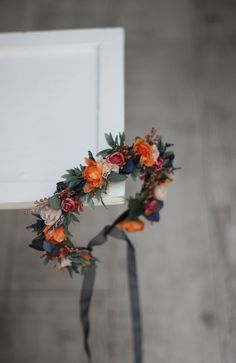 an orange and blue flower crown on top of a white chair