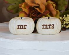 two white pumpkins with the word mr and mrs painted on them sitting next to each other