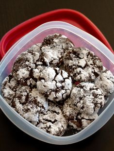 a plastic container filled with chocolate crinkle cookies