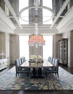 an elegant dining room with chandelier and blue chairs