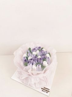 a bouquet of purple and white tulips in a paper wrapper