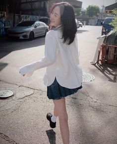 a young woman is walking down the street