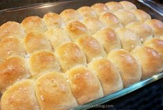 a baking pan filled with bread rolls on top of a stove