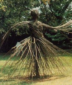 a sculpture made out of branches in the grass