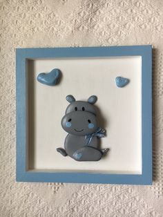 a blue and white frame with a little hippo on it