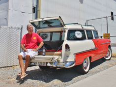 a man sitting on the trunk of an old car