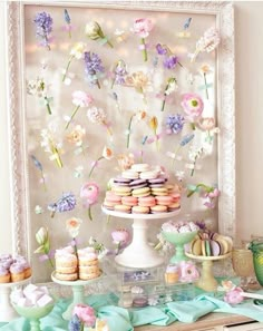 the dessert table is decorated with flowers and macaroons