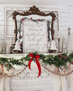 a mantel with stockings and christmas decorations on it in front of a framed sign