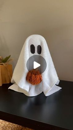 a towel shaped like a ghost holding a piece of food in it's mouth