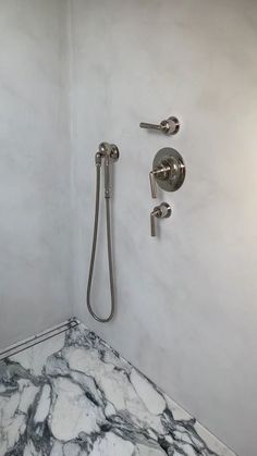 a bathroom with marble counter top and shower head