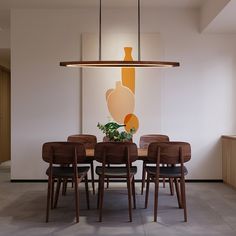 a dining room table with chairs and a vase on the wall in the back ground